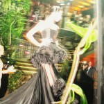 A George Wu design A model wearing a black dress with a frou frou skirt turns around