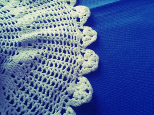 doily A photo of half a doily on a blue tablecloth.