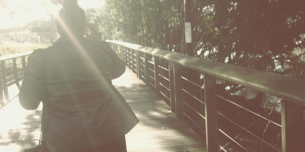 Let's get whimsical! Photo of Natalie's silhouette, she's walking away from the camera along a wooden walkway into a solar flare.