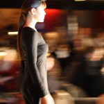 Jolet The profile of a model in a black dress walking.