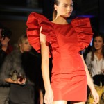 Lulu in Chains Model wearing a red dress with wide and spectacular ruffled sleeves.