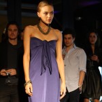 Natalie Chapman Model wearing a navy strapless dress with tie at bust.
