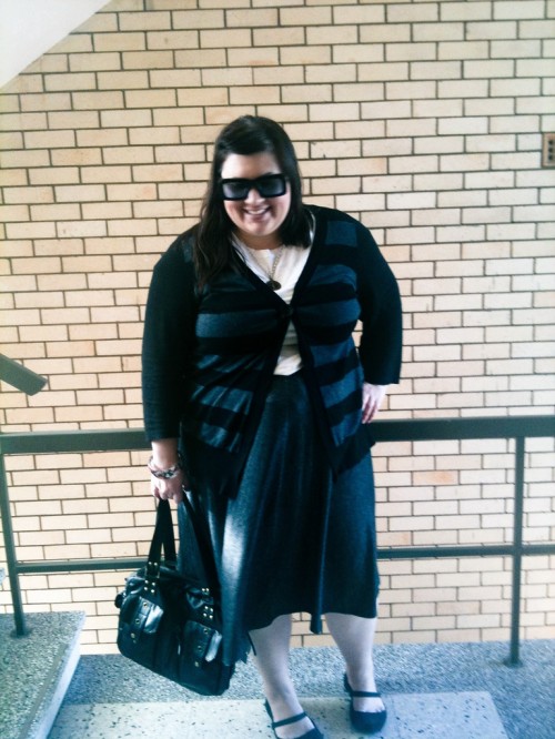 Outfit photo of me wearing a white t-shirt with a grey knee length full skirt and a buttoned grey and black striped cardigan.