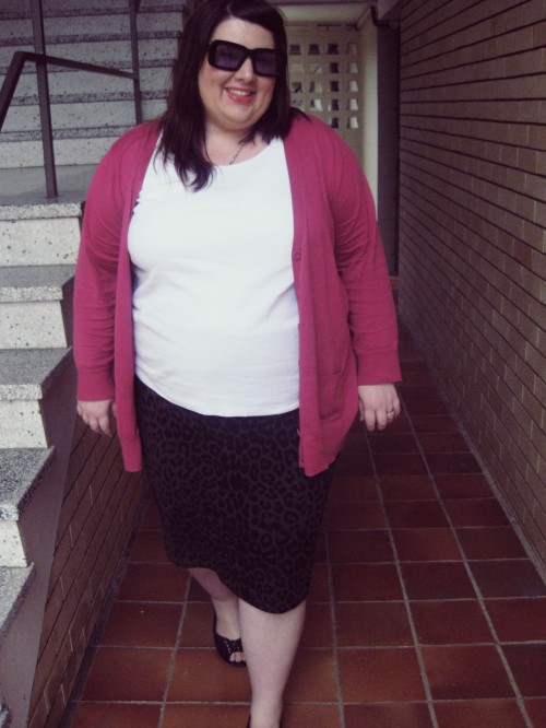 Outfit photo of me wearing a white tank top with a black/ grey animal print pencil skirt and a pink cardigan.