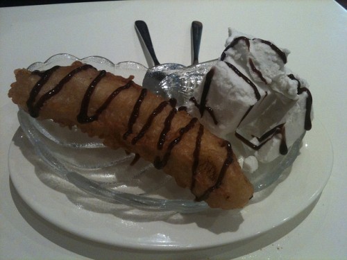 Photo of a fried banana and a dollop of coconut soy ice cream with chocolate sauce drizzled over the top.