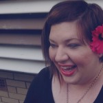 Photo of me laughing with a red hibiscus tucked behind my ear.