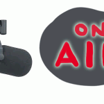 Stock photo of a radio microphone with a grey speech bubble saying "on air".