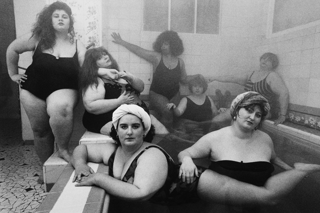 A black and white photo of seven bathing fat women.