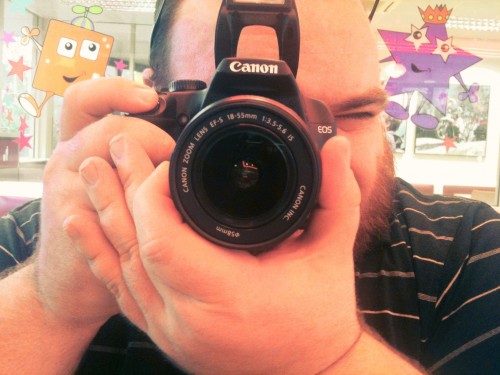 Photo of Nick looking through the viewfinder of a Canon EOS 1000D.