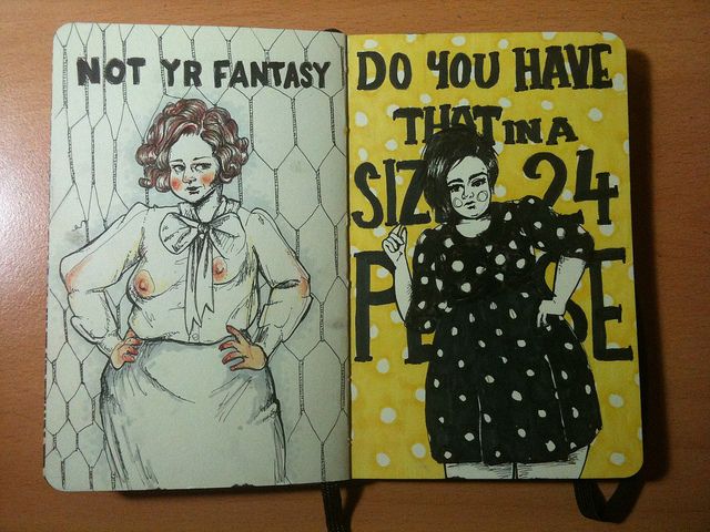 Photo of two drawings on the pages of a Moleskine: left is a pen and pencil drawing of a woman with two differently sized breasts that can be seen through a sheer blouse with a pussy bow. The text above says "Not yr fantasy". Right is an ink drawing of a fat young woman wearing a polka dot dress, the yellow polka dot background has text on it that says "Do you have that in a size 24 please" and is partially obscured by the woman's body.  