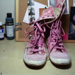 A pair of mid-calf lace up boots in a pink camo colour with pink laces.