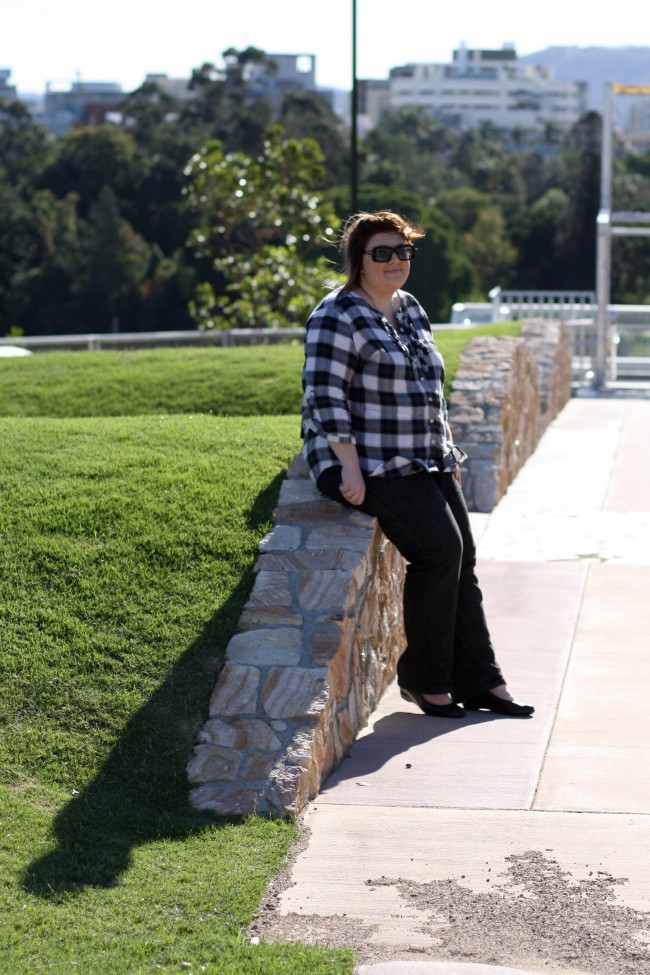 Photo of me sitting on a rock retaining wall.