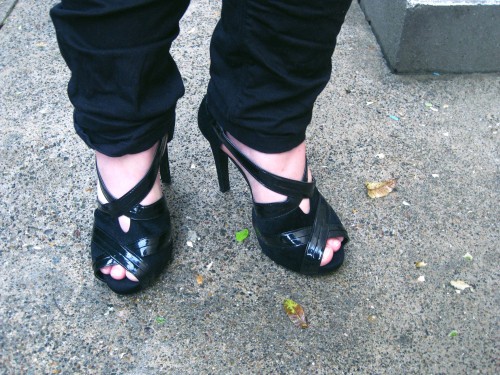 Close up of my shoes - they are black and made of a shiny material and a suede like fabric. There's a small platform  and a very HIGH heel!