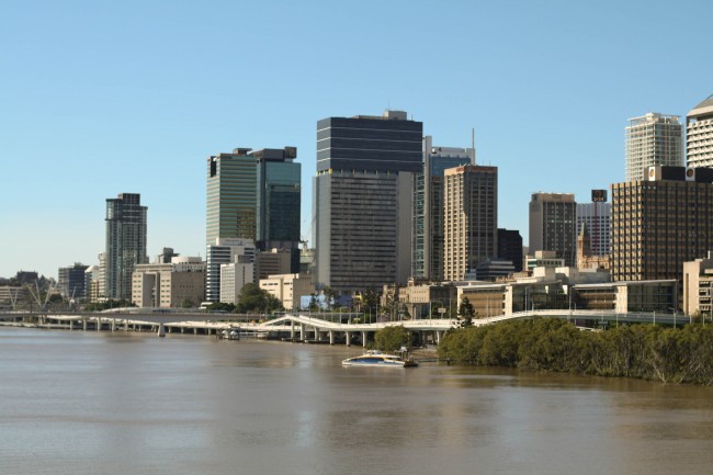 Photo of the Brisbane CBD as seen from the middle of the Goodwill Bridge. The sky is blue but the river looks brown after the recent rain.