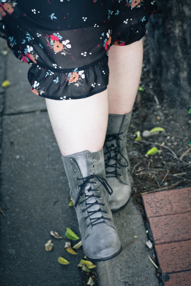 Photo of my legs and feet in grey boots walking along a gutter, you can see a bit of the sheer fabric of my skirt in the frame.
