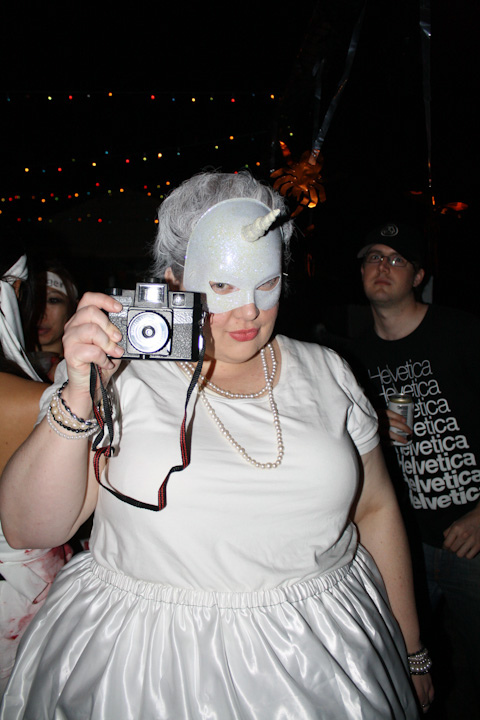Photo of me holding up a Holga camera, while a guy in the background photobombs.