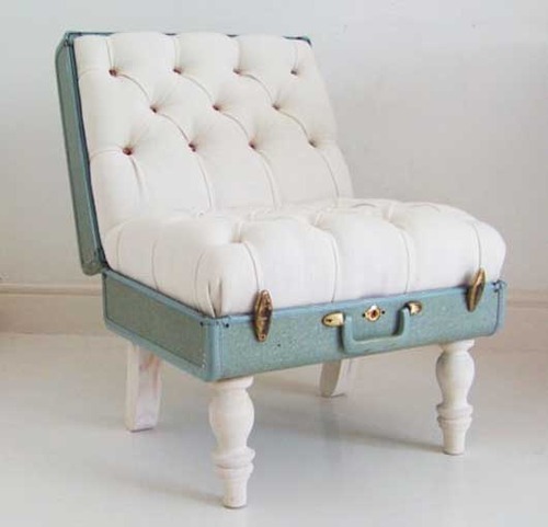 Photo of a seat made from a lovely plush white quilted padding on the inside of an old opened mint green suitcase with ornate white legs attached to the bottom.