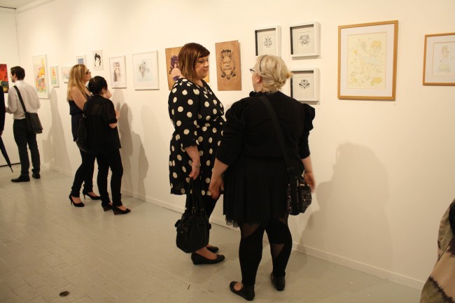 Photo of Zoe and I, two fat ladies tall and short, discussing artwork on the wall in front of us.