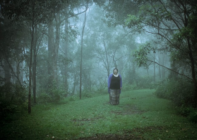 Photo of me in the clearing of the bush which is very thick with foggy white cloud.