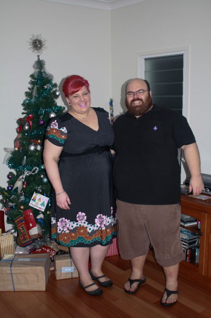 A photo of Nick and I standing to the right of a Christmas tree.