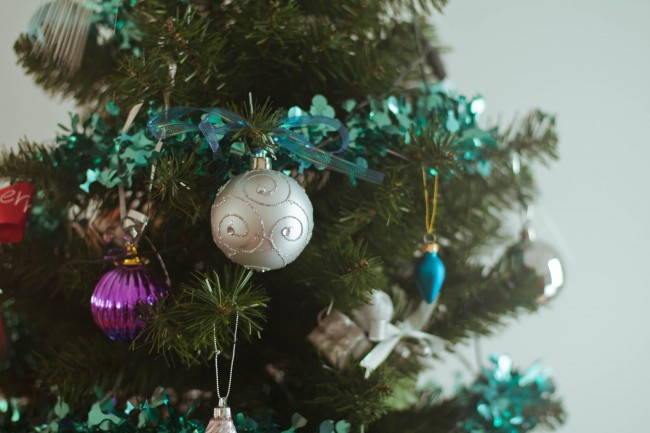 Close up photo of Mum's green (fake) Christmas tree with aqua tinsel and silver, magenta and aqua baubles hanging off the branches.