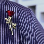 A close up photo of a rose brooch pinned on the lapel of my jacket, much like the brooches of the Vesta Rose agency in the movie She-Devil.