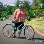 A photo of me standing with my helmet on and my blue bike in front of me.