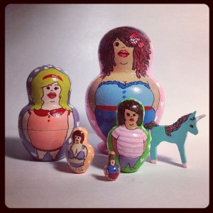 A set of five handpainted matryoshka dolls, each doll painted with a different fat body. Also a tiny unicorn!